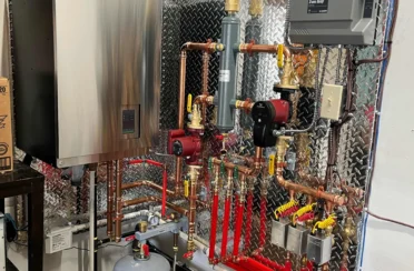 IBC wall-mounted boiler with copper piping, circulator pumps and a Caleffi zone relay installed by Arpi's in a Mahogany, Calgary home