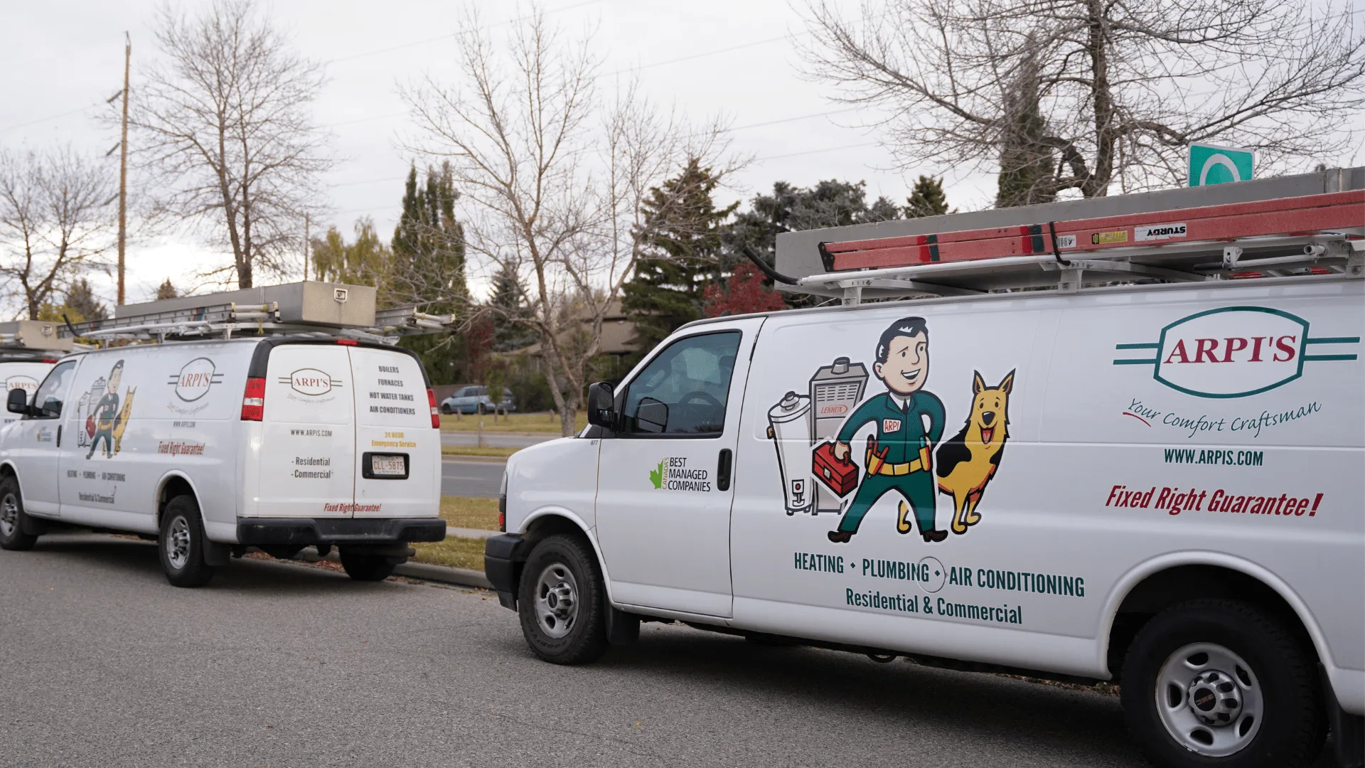 Arpi's branded service vans for heating, plumbing and air conditioning parked on a residential Calgary street