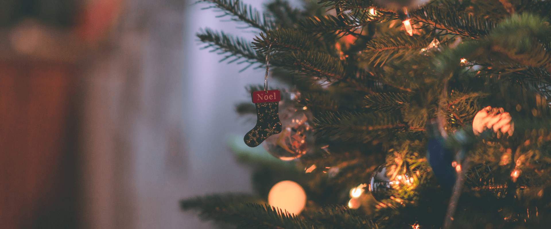 A tiny stocking hangs from a Christmas tree