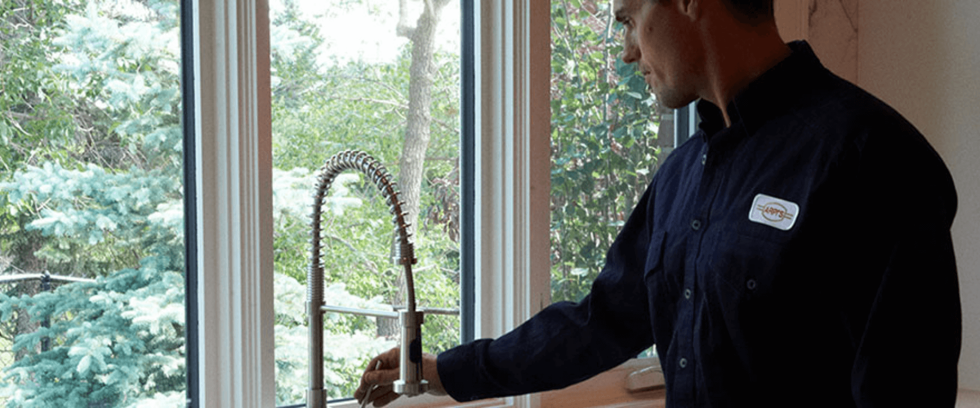 Arpi's technician fixes plumbing in the kitchen