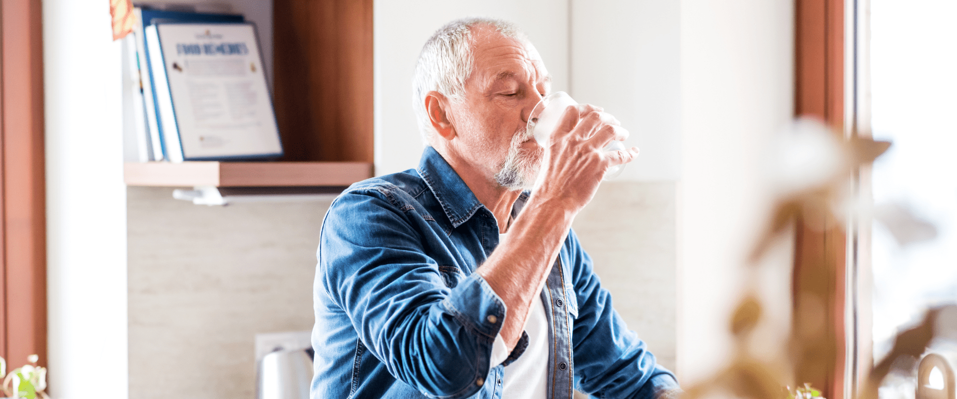 Aging man drinking a glass of water