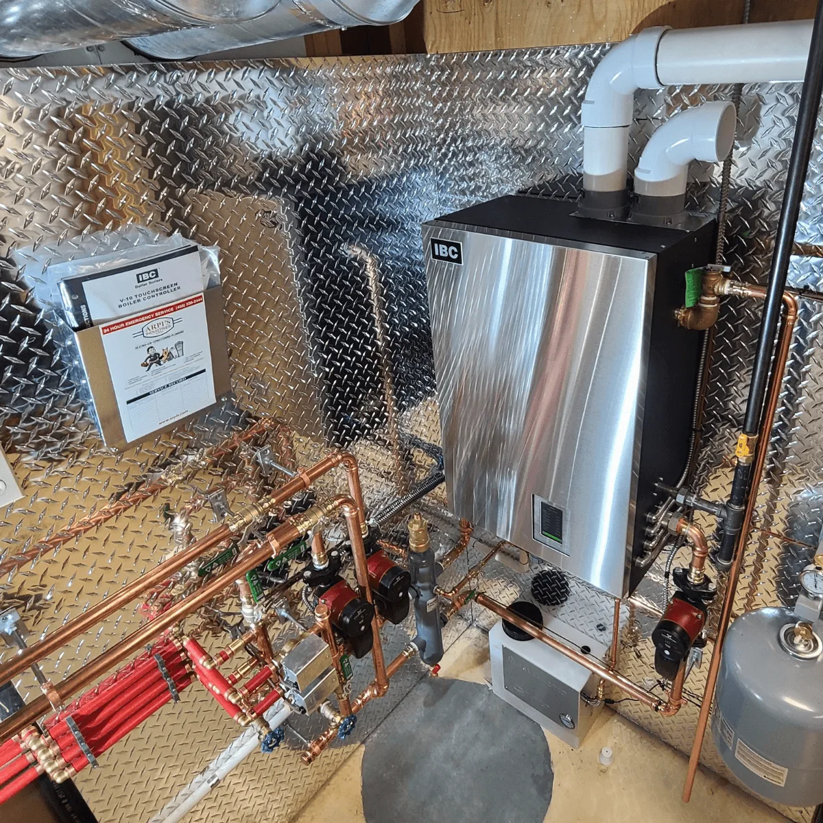 IBC boiler with copper hydronic piping, circulator pumps and expansion tank in a Calgary mechanical room installed by Arpi's
