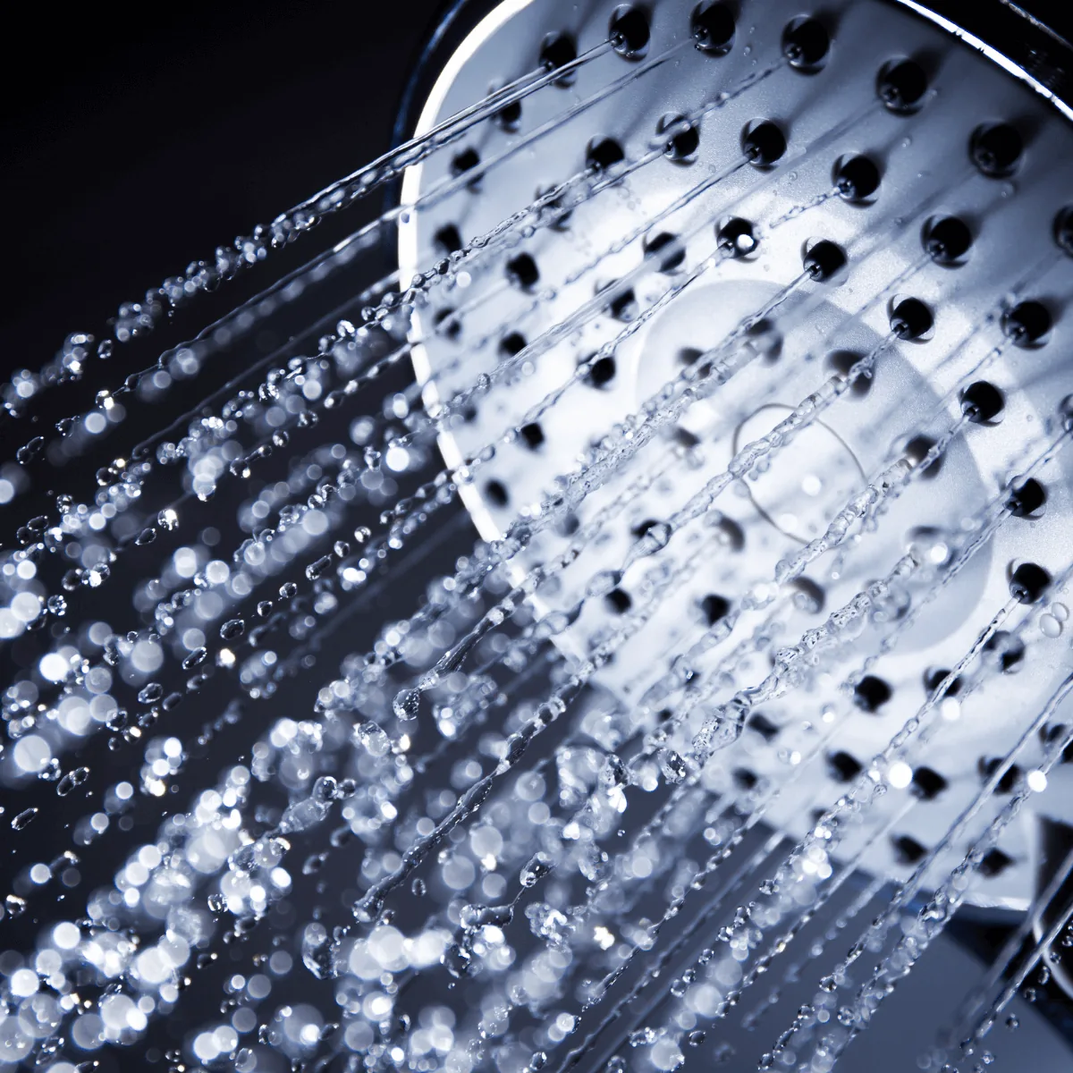 Water flowing from a chrome showerhead, illustrating soft water benefits from a water softener installed by Arpi's in Calgary