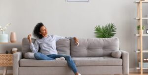 A woman relaxes in her cool home after installing an air conditioner in Calgary